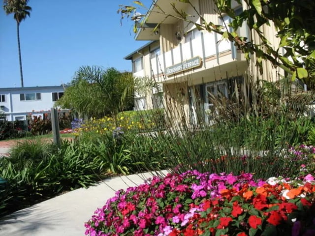 Apartment building entrance with colorful flowers exterior at Berkshire Terrace in Goleta Student Accommodation