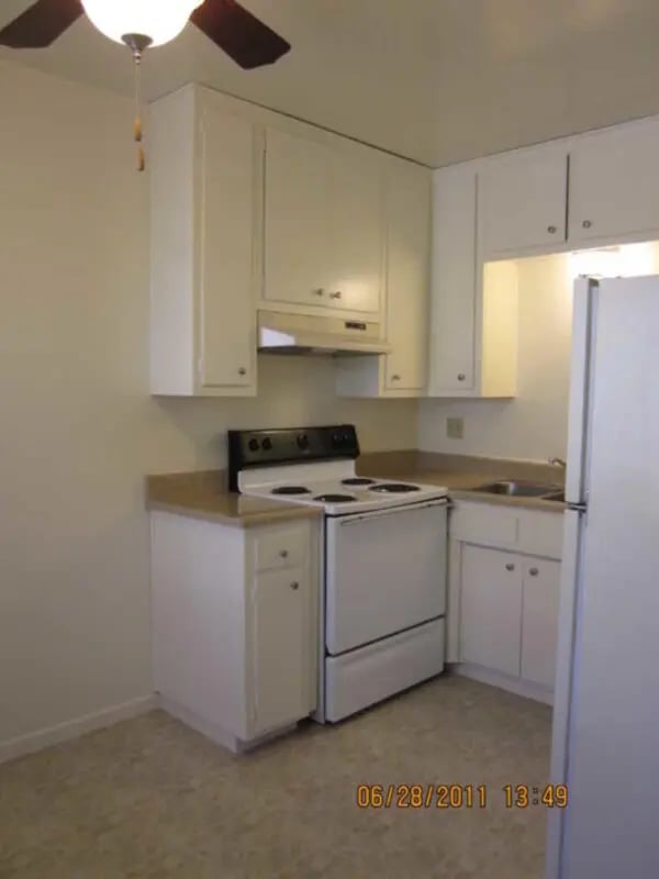 White cabinets stove sink refrigerator kitchen at Berkshire Terrace in Goleta Student Accommodation