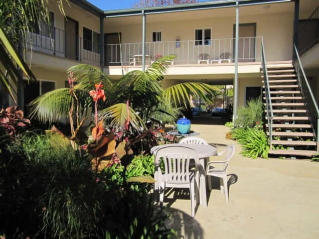 Courtyard with table chairs and tropical plants exterior at Berkshire Terrace in Goleta Student Accommodation