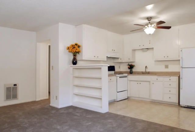 White cabinets bookshelf oven refrigerator kitchen living room at Berkshire Terrace in Goleta Student Accommodation