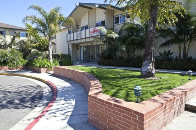 Apartment building entrance with palm trees and grass exterior at Berkshire Terrace in Goleta Student Accommodation