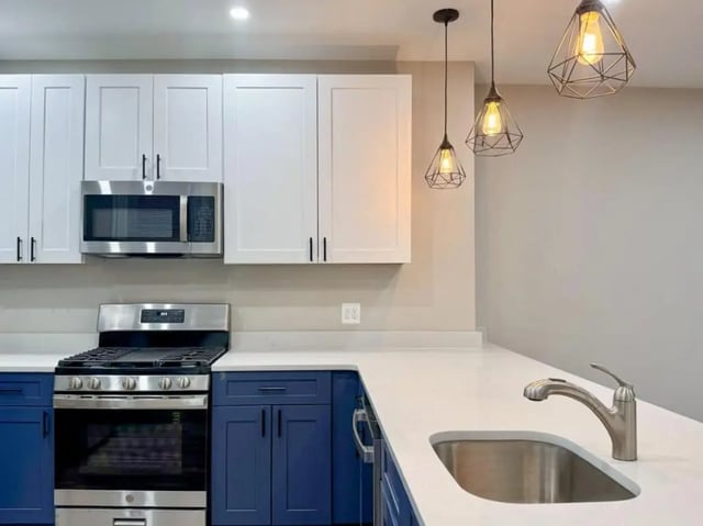 Modern kitchen with white cabinets blue base cabinets stove kitchen at Campus Apartments Philadelphia in Philadelphia Student Accommodation