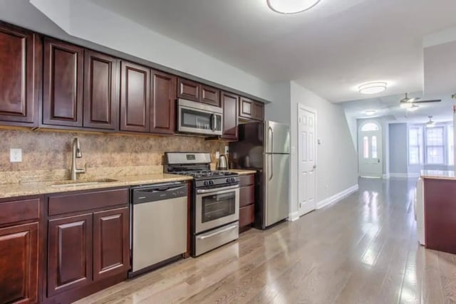 Kitchen with stainless steel appliances and dark cabinets kitchen at Campus Apartments Philadelphia in Philadelphia Student Accommodation