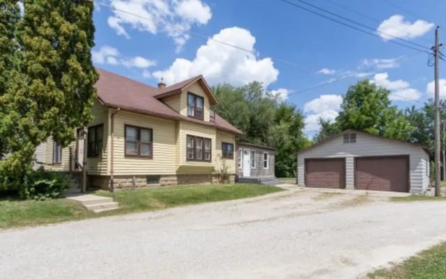 Yellow house with two garage doors exterior at Better Ball State Rentals in Muncie Student Accommodation
