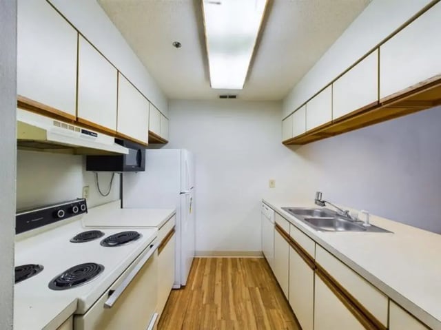 White cabinets stove refrigerator and sink kitchen at Chesterfield Apartments Muncie in Muncie Student Accommodation