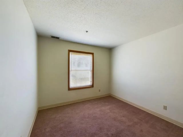 Empty room with brown carpet and window bedroom at Chesterfield Apartments Muncie in Muncie Student Accommodation