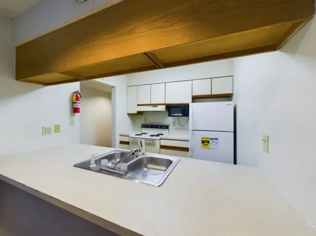 Sink refrigerator stove and cabinets kitchen at Chesterfield Apartments Muncie in Muncie Student Accommodation