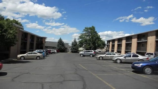 Apartment buildings with cars in parking lot exterior at Alpine Flats (NOW UNIVERSITY LANDING) in Logan Student Accommodation