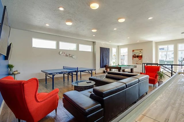 Ping pong table, pool table, sofa, red chairs living room at Alpine Flats (NOW UNIVERSITY LANDING) in Logan Student Accommodation