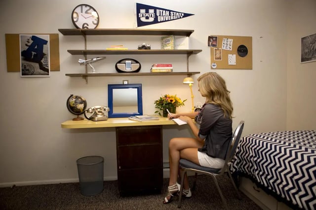 Student desk with globe phone girl writing bedroom study area at Alpine Flats (NOW UNIVERSITY LANDING) in Logan Student Accommodation