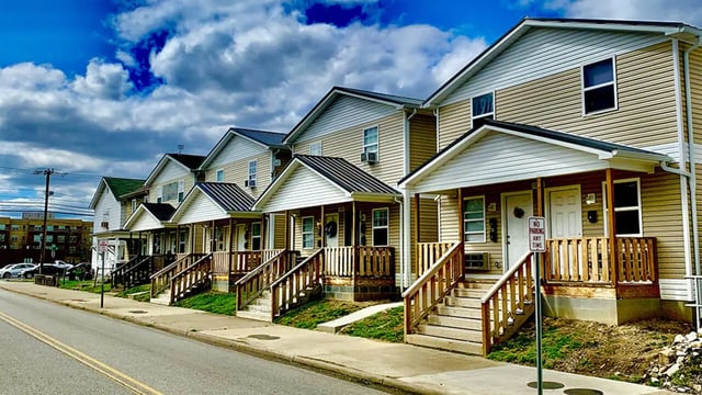 Row of beige townhouses with stairs exterior at Big Green Properties in Huntington Student Accommodation