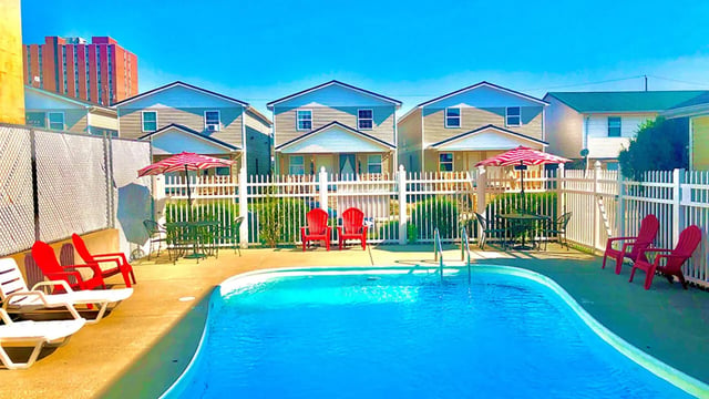 Lounge chairs and umbrella by pool area exterior at Big Green Properties in Huntington Student Accommodation