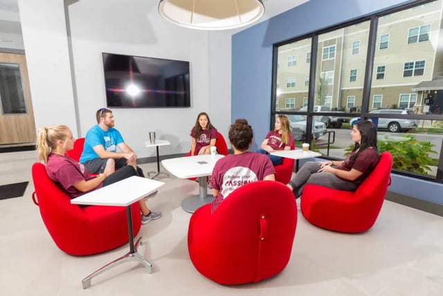 Students sitting in red beanbag chairs living room at Beacon Commons in Springfield Student Accommodation