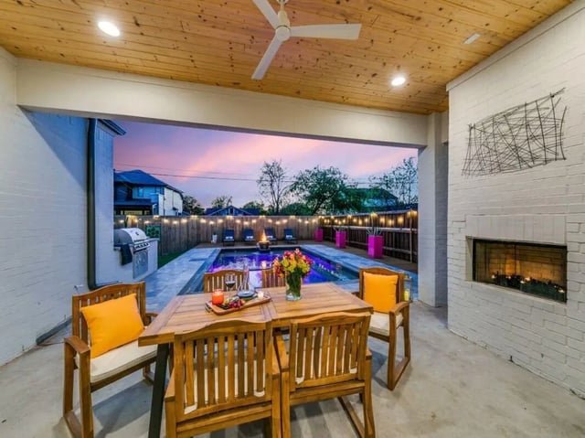 Wooden table chairs fireplace pool patio exterior at Carpediem Homes in Dallas Student Accommodation