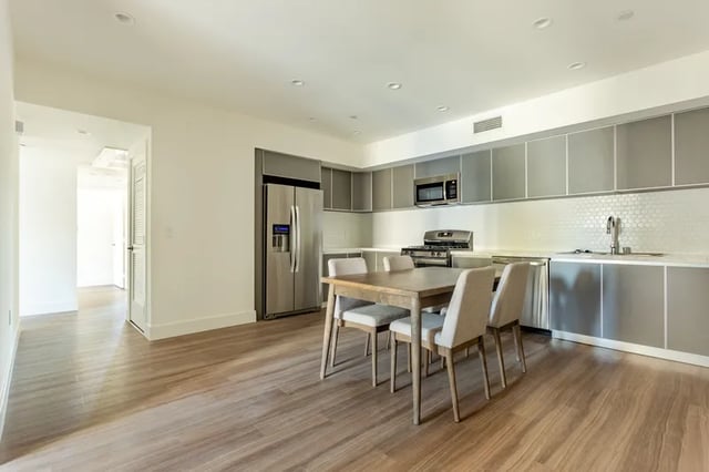 Dining table with chairs and kitchen setup kitchen at 1025 Berendo Villas in Los Angeles Student Accommodation