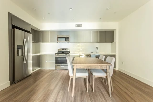 Stainless steel refrigerator stove microwave dining table kitchen at 1025 Berendo Villas in Los Angeles Student Accommodation