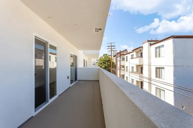 Balcony with sliding doors overlooks apartment buildings Balcony exterior at 1025 Berendo Villas in Los Angeles Student Accommodation