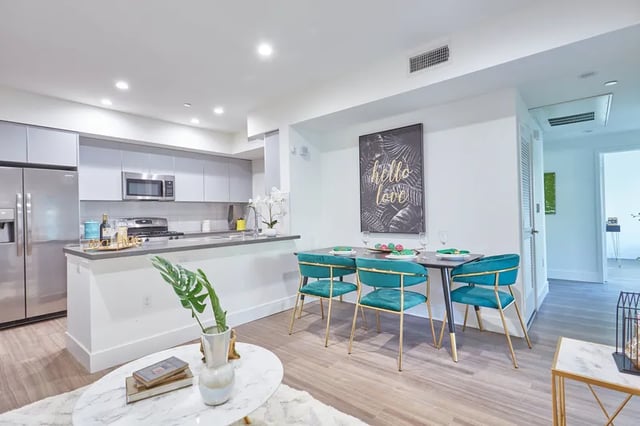 Modern kitchen dining area with stainless steel appliances and teal chairs dining area at 1025 Berendo Villas in Los Angeles Student Accommodation