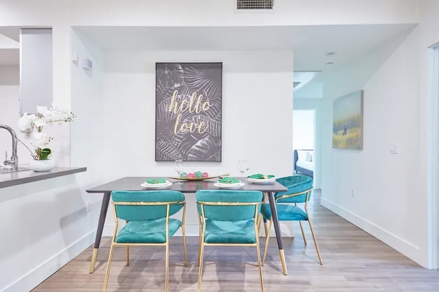 Dining table with teal chairs artwork wall Painting dining area at 1025 Berendo Villas in Los Angeles Student Accommodation