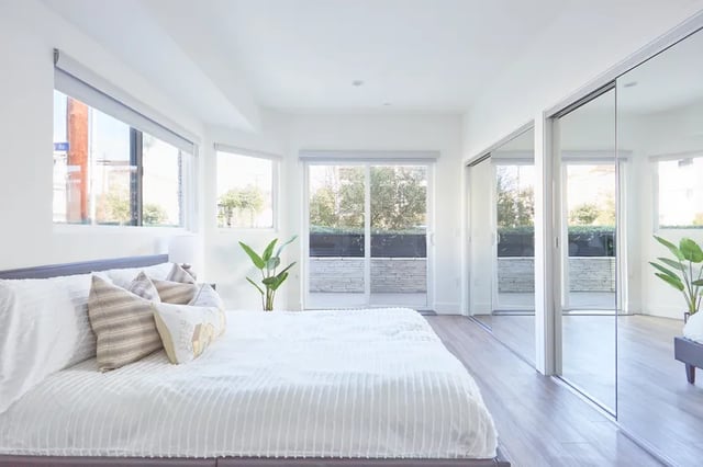 White bed with pillows sliding mirrored closet bedroom at 1025 Berendo Villas in Los Angeles Student Accommodation