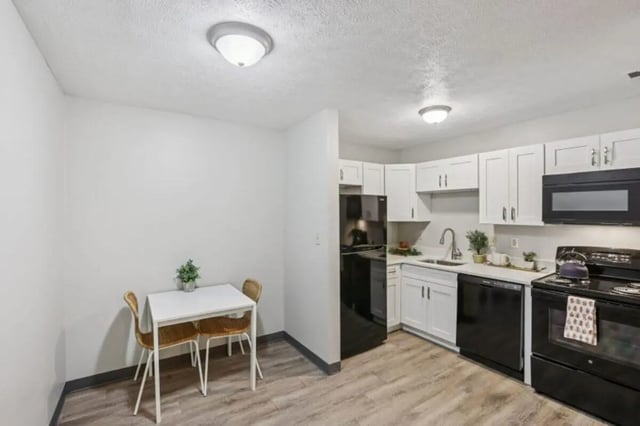 Table with two chairs black appliances kitchen at Beacon Hill Apartments in Muncie Student Accommodation