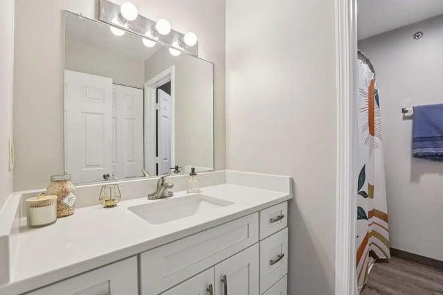 Sink vanity with mirror and shower curtain Bathroom at Beacon Hill Apartments in Muncie Student Accommodation
