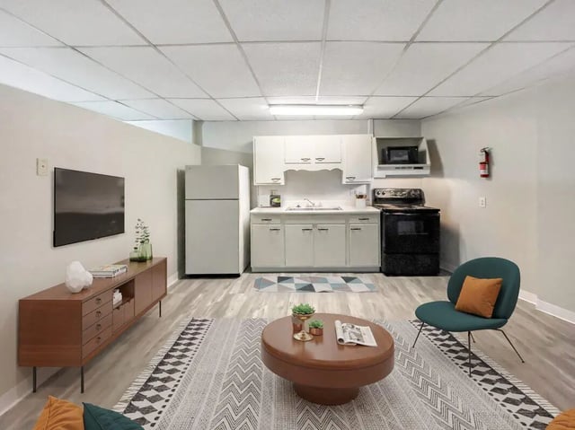 TV refrigerator sink stove seating living room kitchen at Beacon Hill Apartments in Muncie Student Accommodation