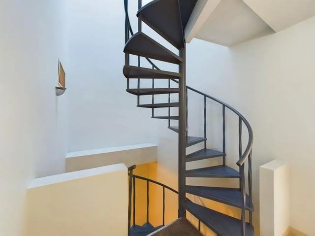 Metal spiral staircase with small wall shelf Staircase at Beacon Hill Apartments in Muncie Student Accommodation