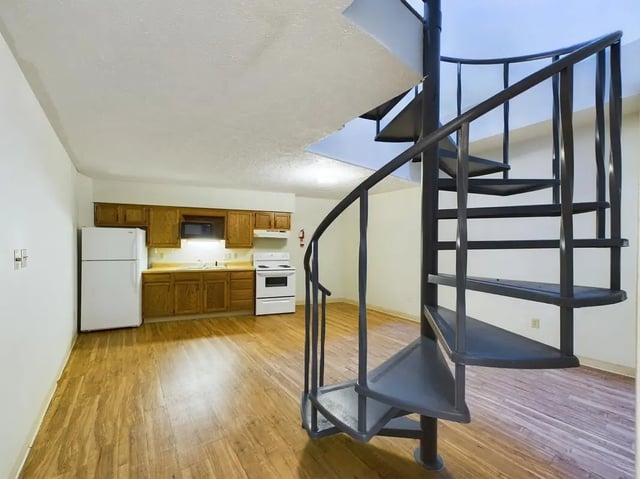 Spiral staircase near kitchen area with appliances kitchen at Beacon Hill Apartments in Muncie Student Accommodation