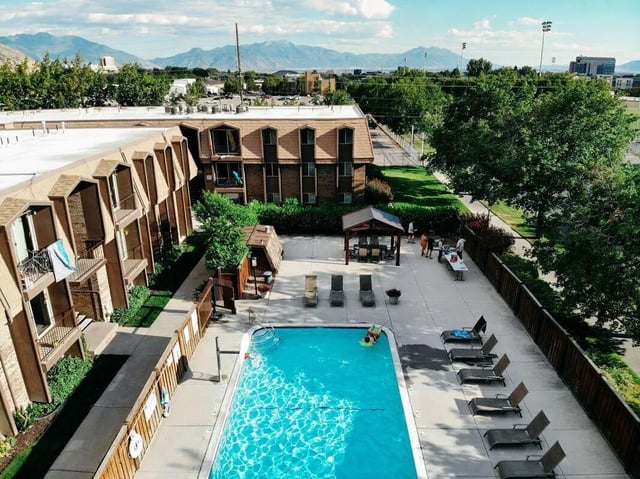 Apartment buildings pool lounge chairs and trees exterior at Alta Apartments in Provo Student Accommodation