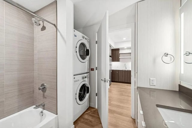 Stacked washer dryer shower tub vanity kitchen view bathroom at Alta Peak in Portland Student Accommodation