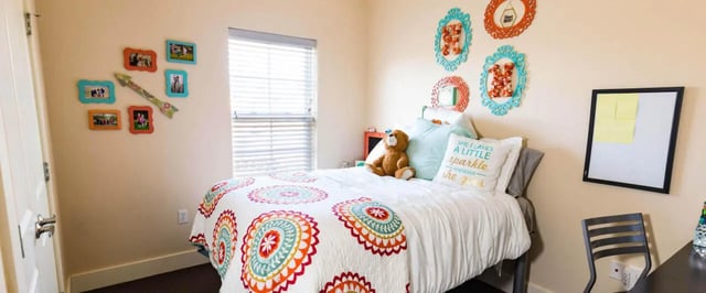 Bed with colorful quilt and framed photos Bedroom at Beacon Springfield in Springfield Student Accommodation