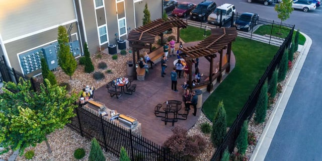 People gathered around fire pit grills and seating exterior at Beacon Springfield in Springfield Student Accommodation