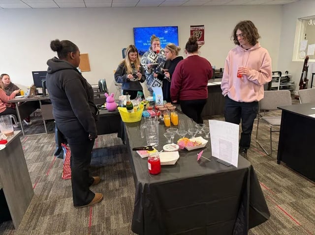 Food drinks and people gather around a table Event Area at Advantage Point Student Apartments in Kutztown Student Accommodation
