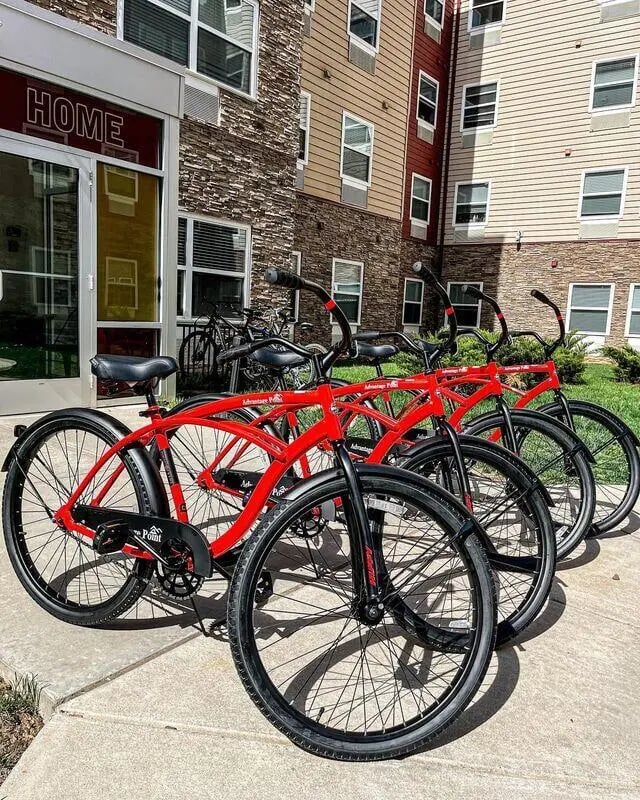 Red bicycles parked outside apartment building exterior at Advantage Point Student Apartments in Kutztown Student Accommodation