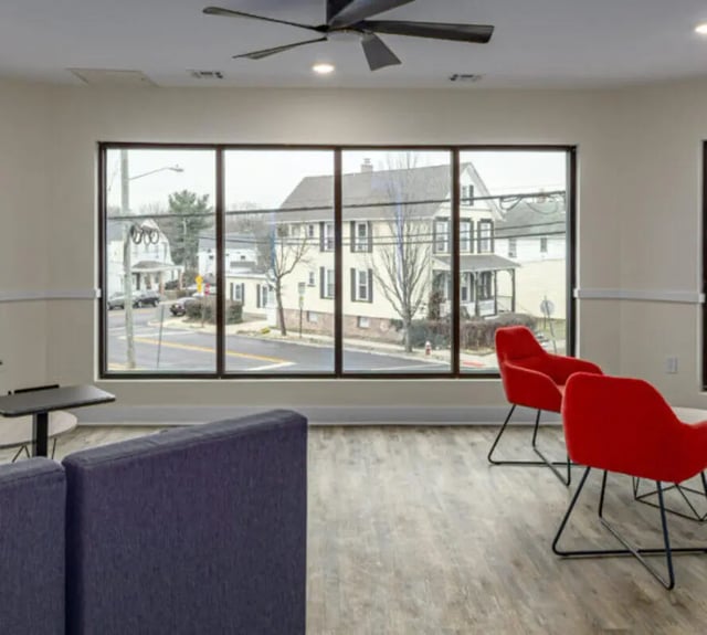 Purple couch red chairs large window living room at 44 Courtlandt in New Brunswick Student Accommodation