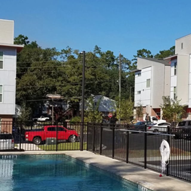 Apartment buildings with pool and parked cars exterior at Arive850 in Tallahassee Student Accommodation