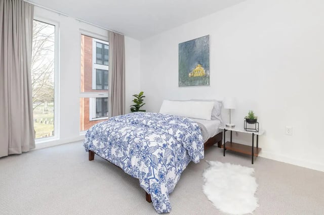 Bed with blue floral duvet side table and rug Bedroom at 11 East Pleasant in Amherst Student Accommodation