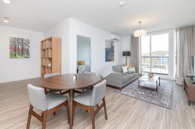 Round dining table grey chairs sofa living room at 11 East Pleasant in Amherst Student Accommodation