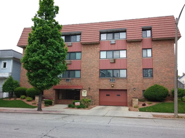 Brick building with many windows and garage exterior at Campus Court in Milwaukee Student Accommodation