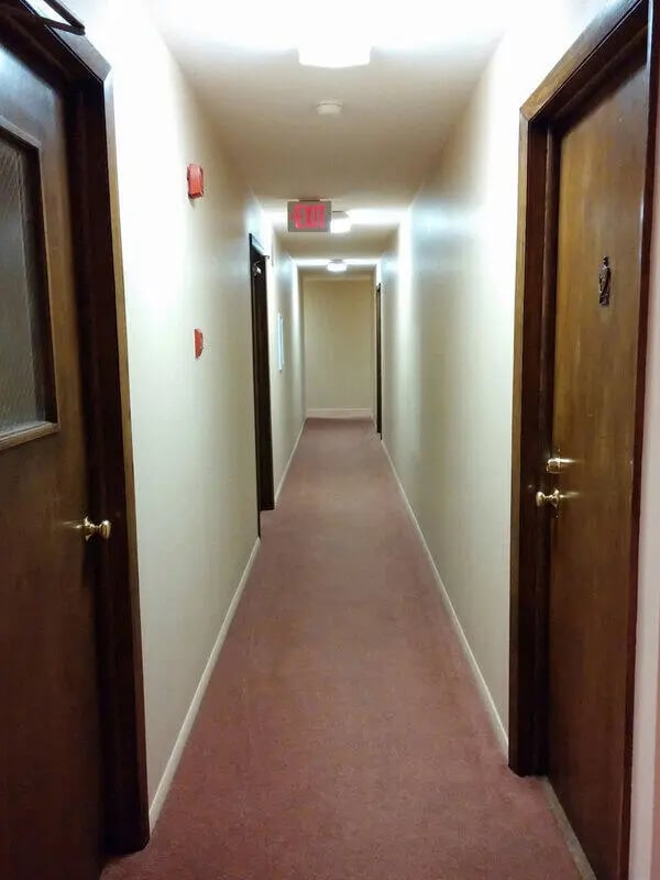 Long hallway with red carpet and doors hallway at Campus Court in Milwaukee Student Accommodation