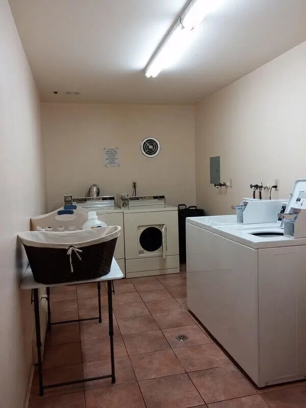 Laundry machines basket and sink utility area at Campus Court in Milwaukee Student Accommodation