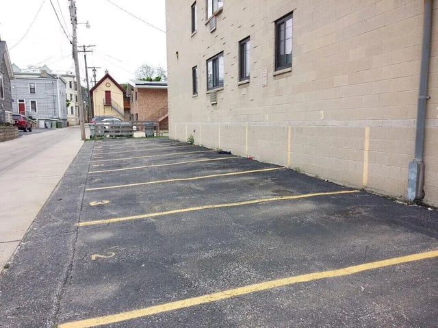 Empty parking lot with yellow lines and numbers exterior at Campus Court in Milwaukee Student Accommodation