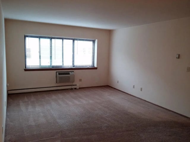 Empty room window air conditioner blinds carpet living room at Campus Court in Milwaukee Student Accommodation