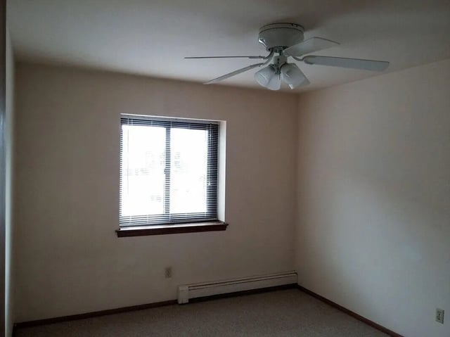 Ceiling fan window blinds radiator interior bedroom at Campus Court in Milwaukee Student Accommodation