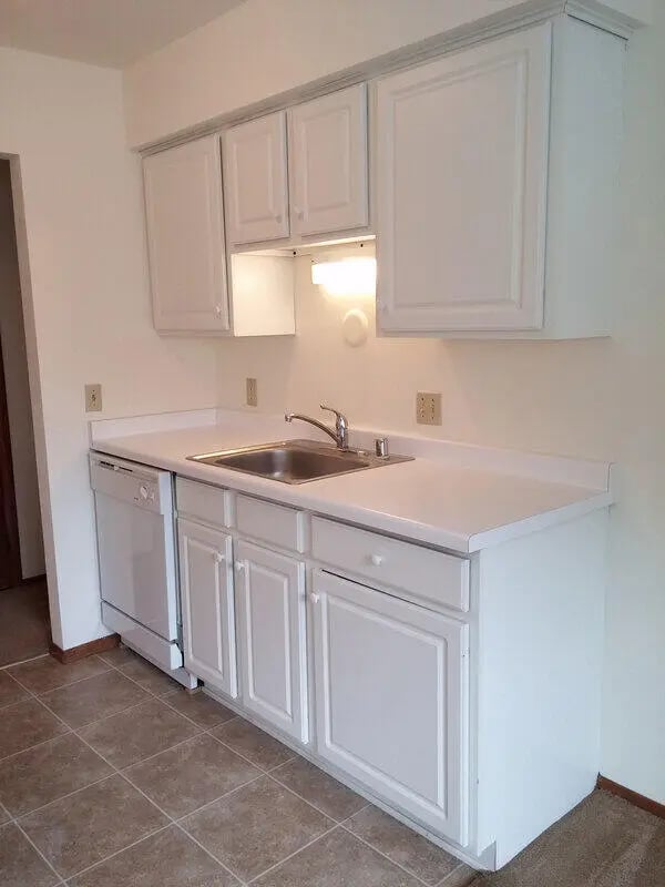 White cabinets sink dishwasher tiled floor kitchen at Campus Court in Milwaukee Student Accommodation