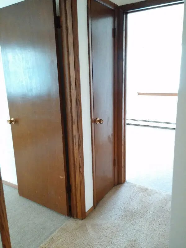 Hallway with wooden doors and carpet Interior at Campus Court in Milwaukee Student Accommodation