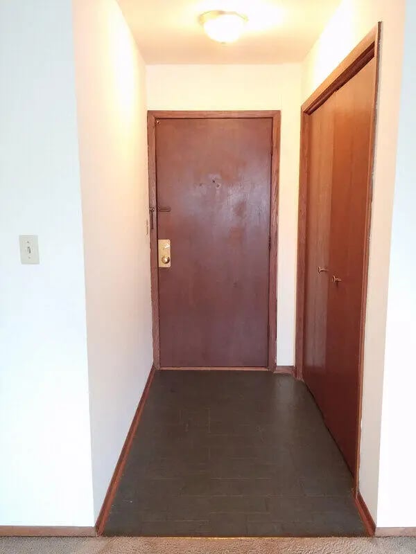 Doorway with two brown doors and dark floor entry at Campus Court in Milwaukee Student Accommodation