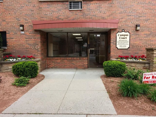 Entrance with brick building and signage Exterior at Campus Court in Milwaukee Student Accommodation