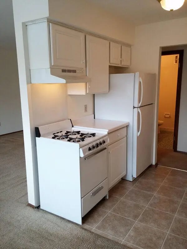White stove refrigerator and cabinets kitchen area at Campus Court in Milwaukee Student Accommodation